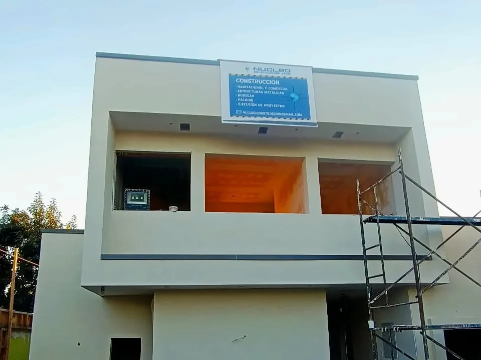 Casa de dos pisos construida por Núcleo, con el letrero de Núcleo Construcción en la fachada