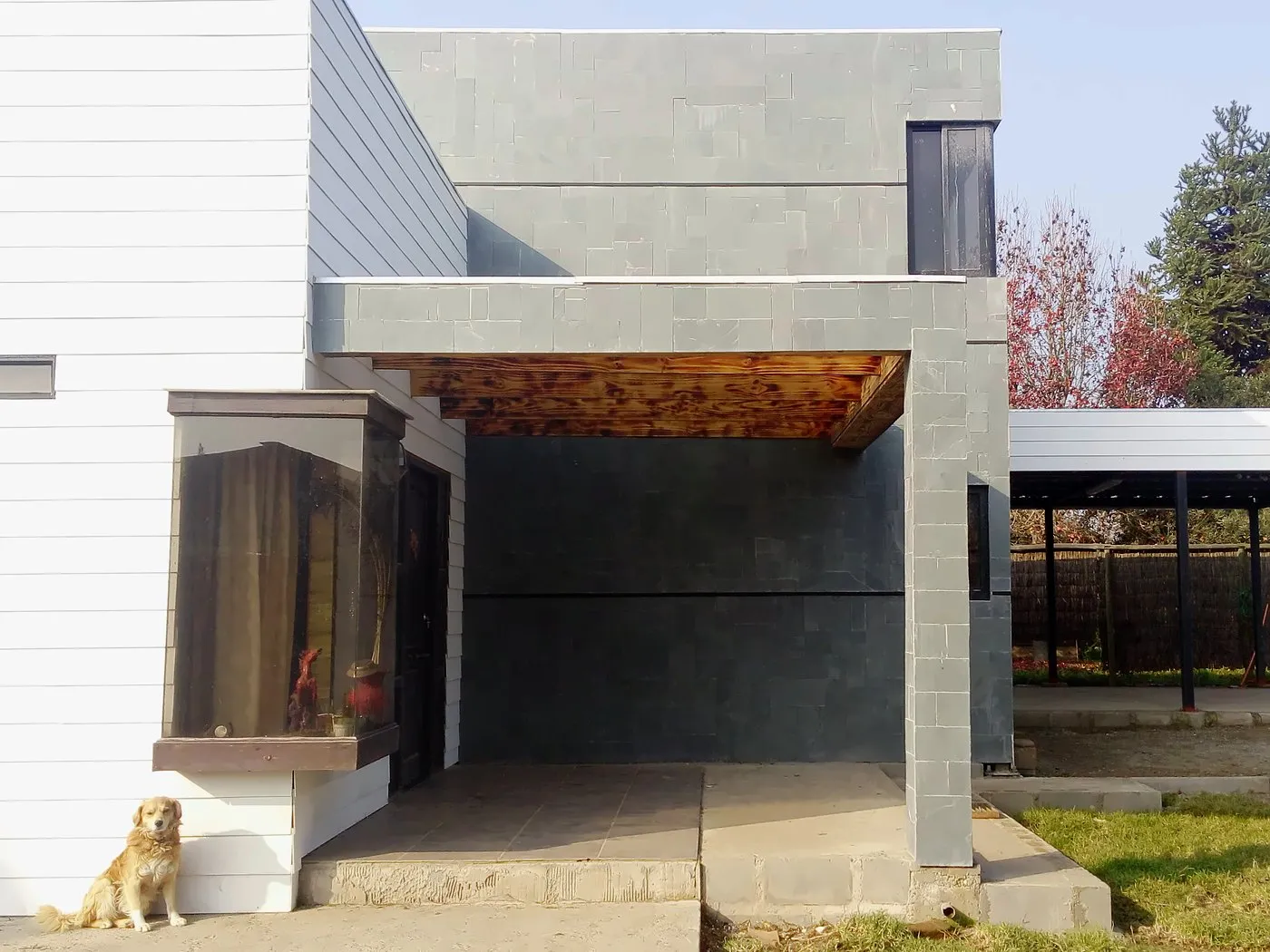 Vivienda terminada: Construcción, revestimiento de piedra y alero de madera